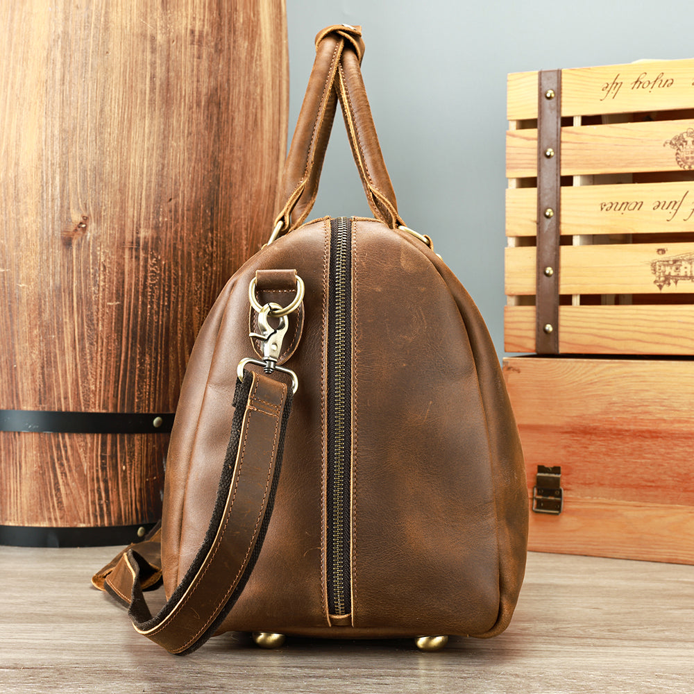 Coffee leather travel duffel, side profile with shoulder strap