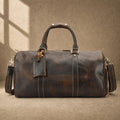 Deep coffee cowhide weekender duffle, front hero view with luggage tag