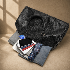 Black embossed leather travel duffel, top-down capacity view