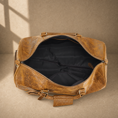 Open cognac floral leather rolling duffle showing empty lined interior