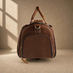 Side view of cognac cowhide rolling garment bag with zip pocket
