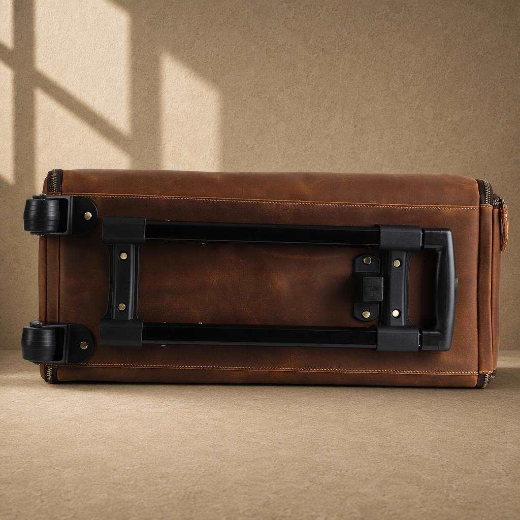 Bottom view of cognac rolling garment bag showing trolley frame and wheels