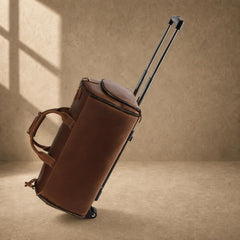 Cognac cowhide rolling travel bag in motion with telescoping handle