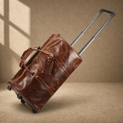 Coffee leather travel duffel tilted on wheels with handle extended