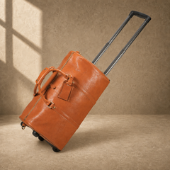 Cognac leather travel duffel tilted on wheels with handle extended