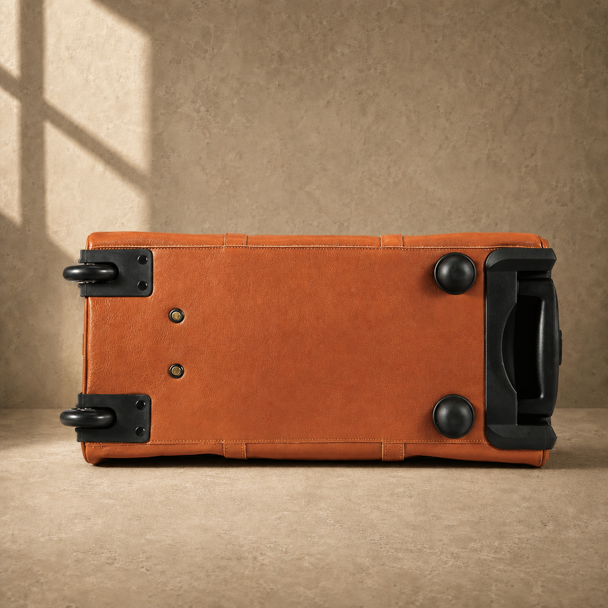 Base view of cognac rolling duffel showing wheels and protective feet