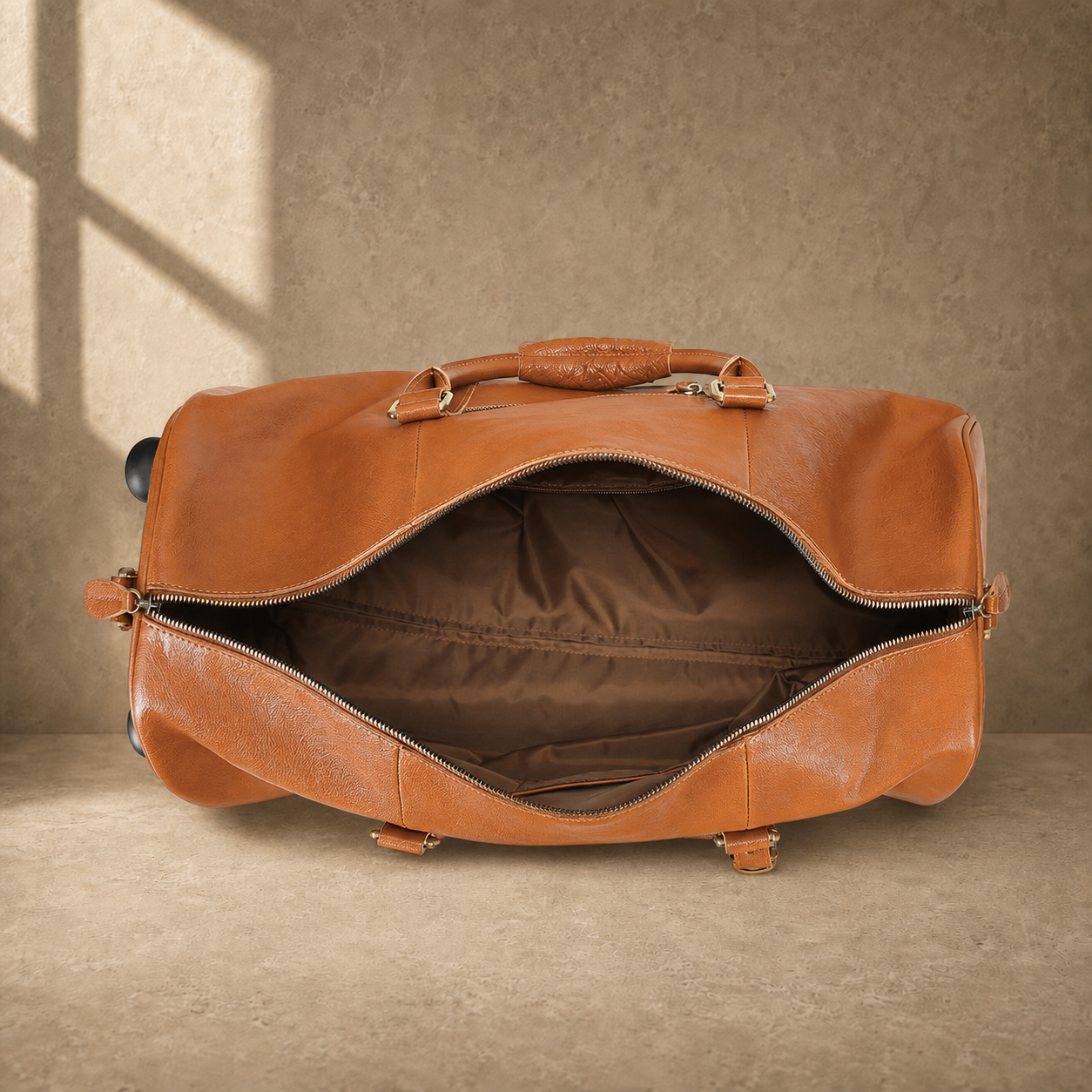 Open cognac leather rolling duffel showing empty lined interior