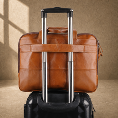Cognac laptop briefcase secured to suitcase trolley handle