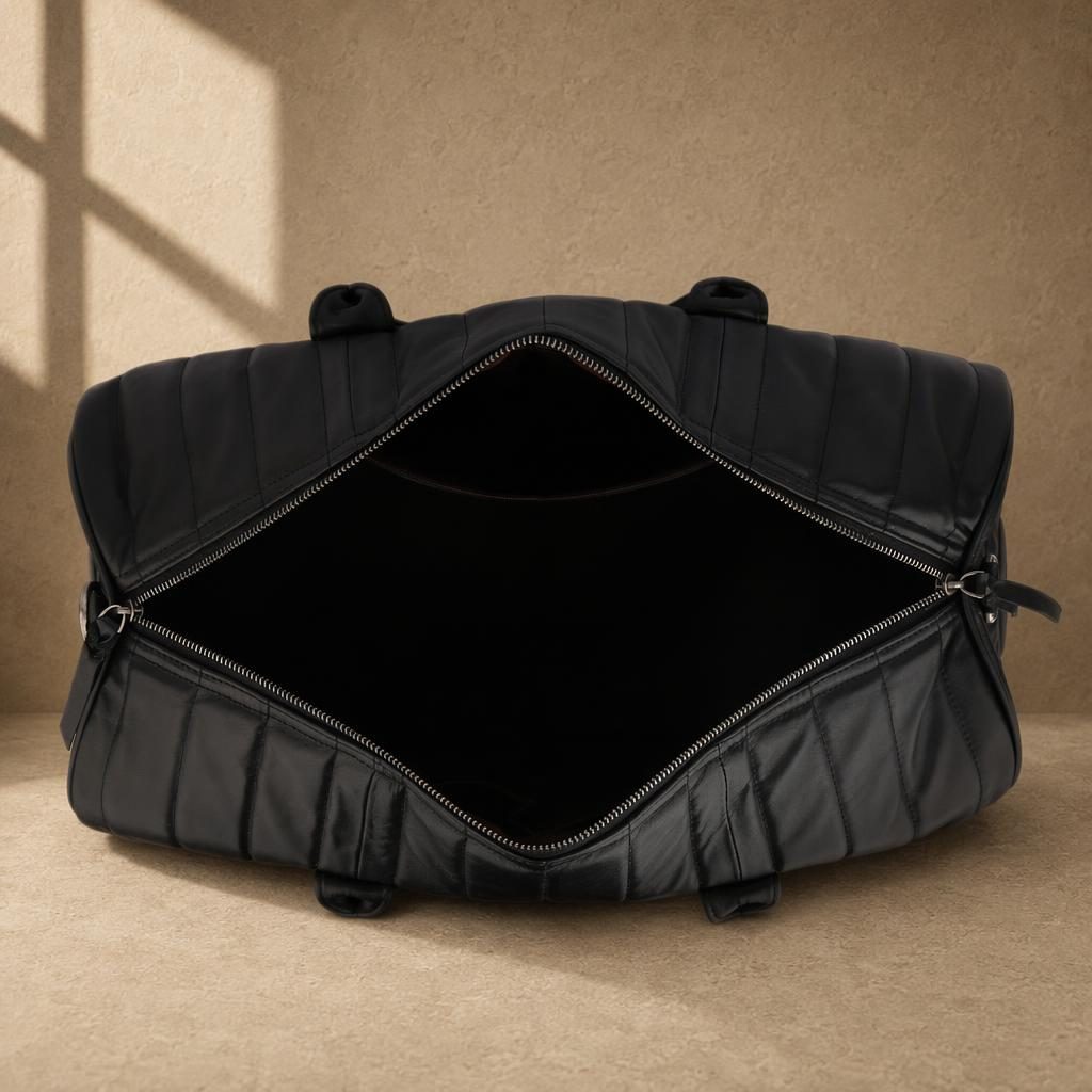 Black quilted cowhide travel duffel showing empty main compartment