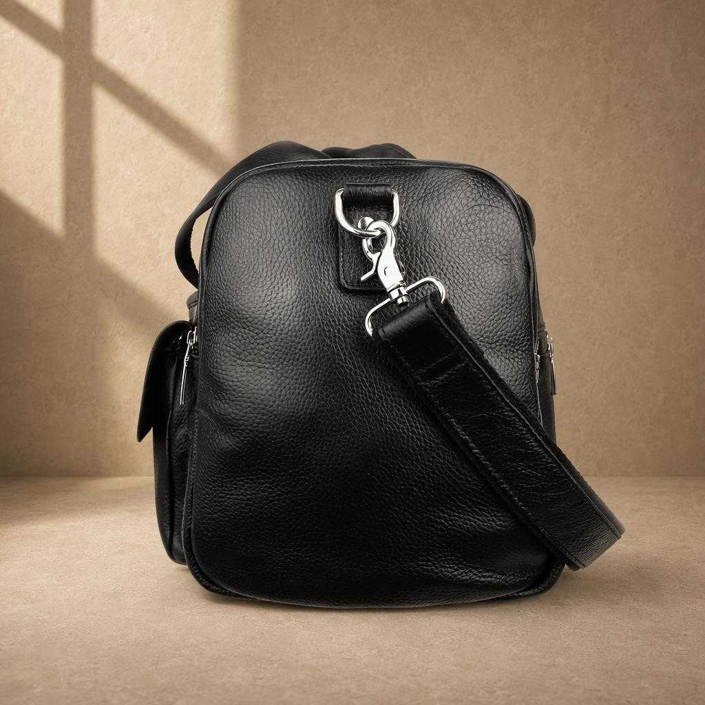 Black pebbled cowhide utility duffel, side profile with shoulder strap