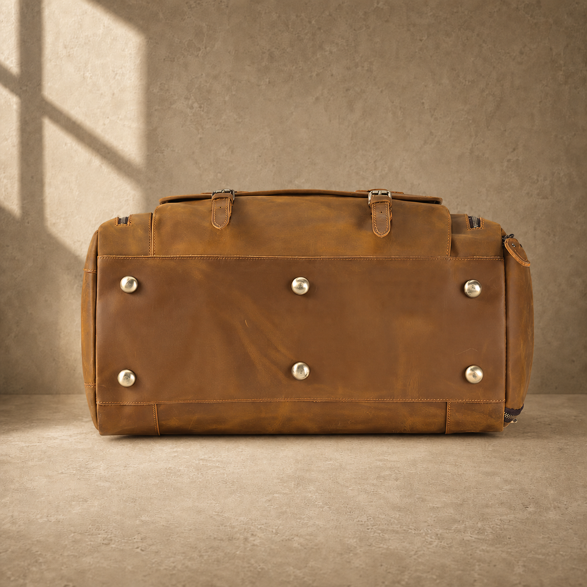 Brown leather travel bag showing protective metal base feet