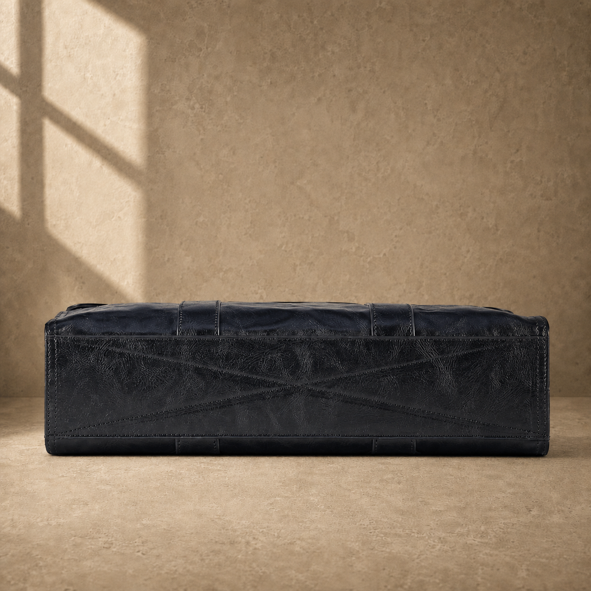 Black wrinkled leather briefcase, alternate cross-stitched base view