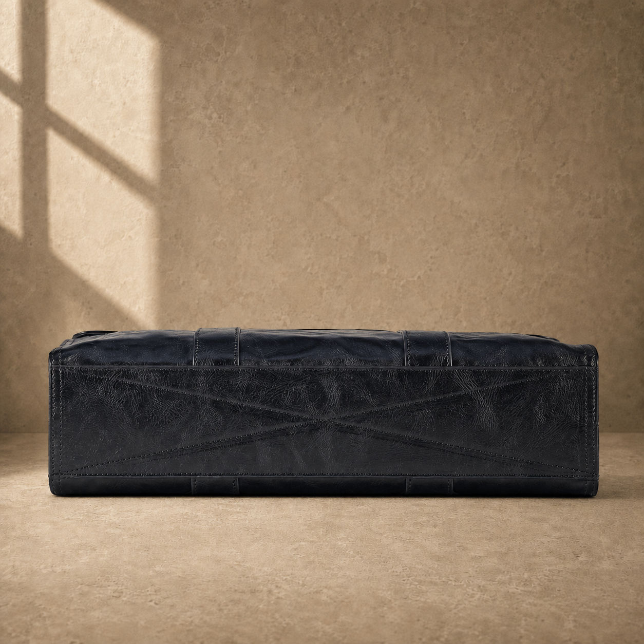 Black wrinkled leather briefcase, alternate cross-stitched base view