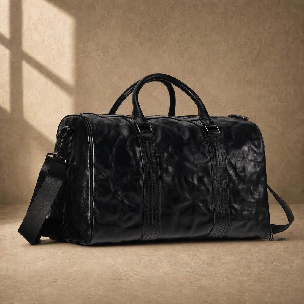 Black cowhide leather weekender duffel bag with handles and shoulder strap, three-quarter view