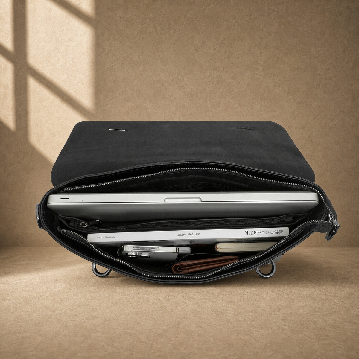 Black leather commuter messenger bag, packed laptop compartment