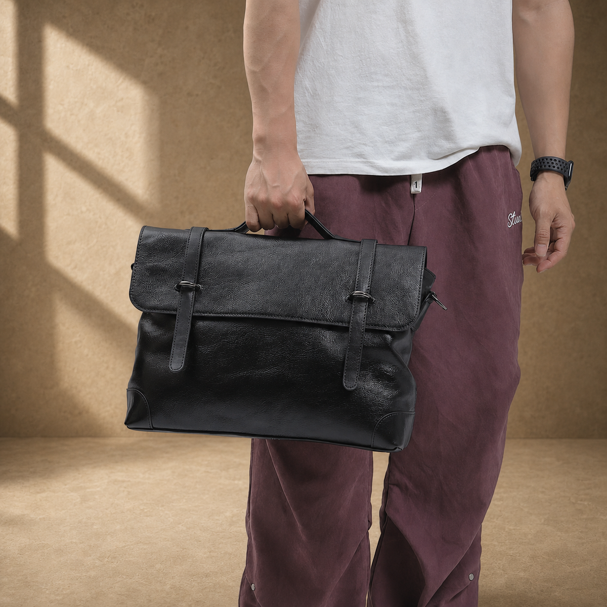 Black leather commuter messenger bag carried by top handle