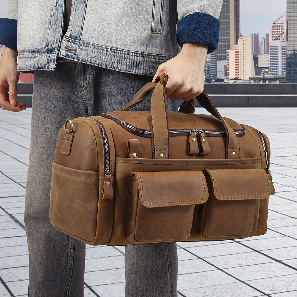 Bottom view showing protective feet on the brown leather duffle