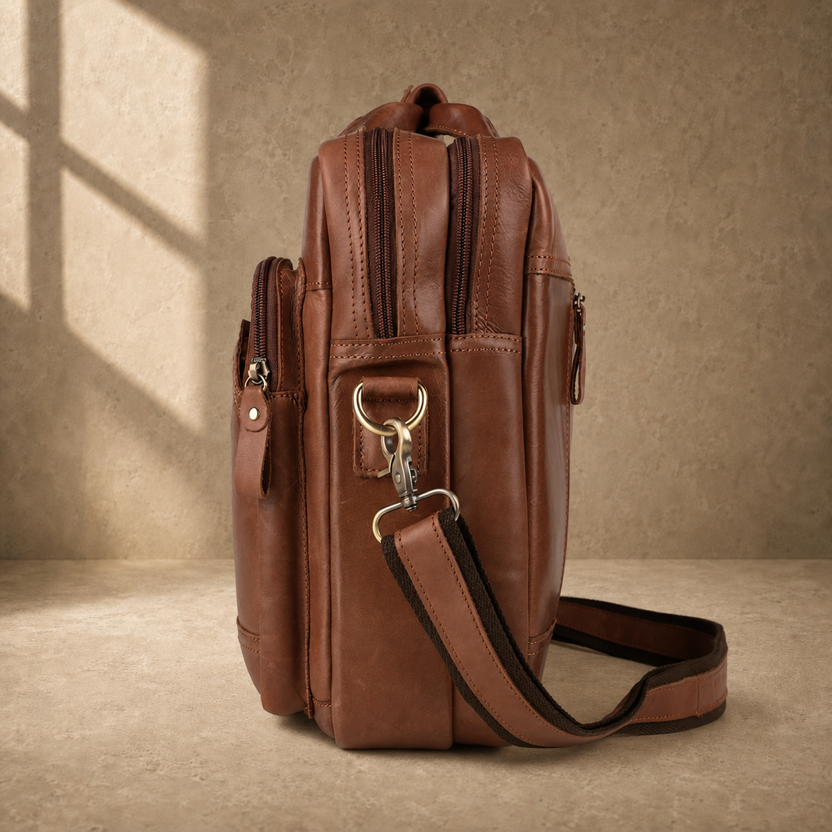 Brown cowhide dual-zip briefcase bag, side profile with shoulder strap