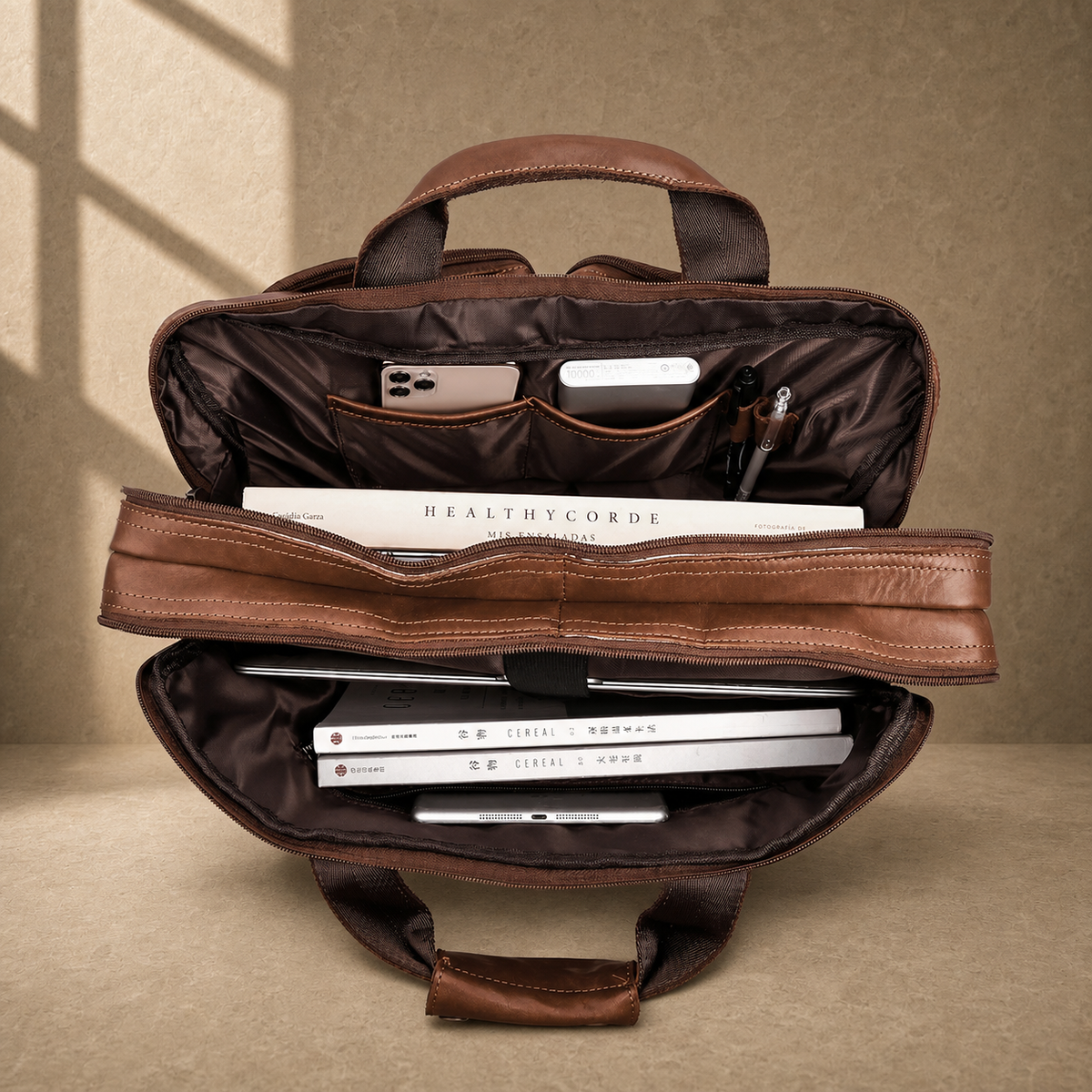 Brown cowhide dual-zip briefcase bag, packed laptop capacity view