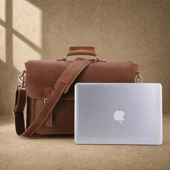 Brown leather buckled work briefcase shown with laptop for scale